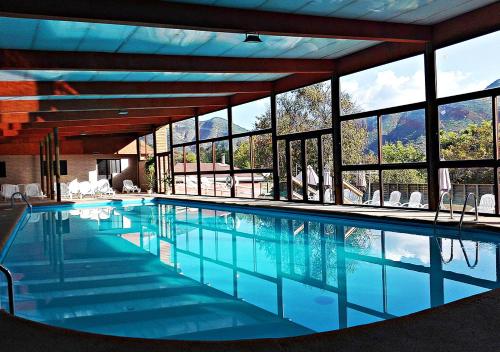 奧爾穆埃的住宿－歐穆厄山會議中心度假酒店，一座大型游泳池,位于一座带窗户的建筑内