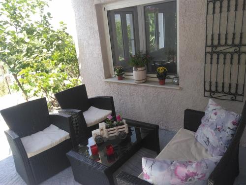 a patio with two chairs and a coffee table at House with fruit trees, olive trees, and sea view. in Vathý