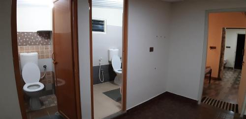 a bathroom with two toilets and a mirror at SilverShine Homestay in Chikmagalūr