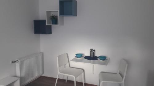 een witte tafel en 2 stoelen in een kamer bij Apartmán Relax Hamry in Nové Hamry