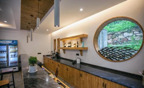 a bar in a restaurant with a round window at National Forest Park(Yangjiajie ) MINI Inn in Zhangjiajie