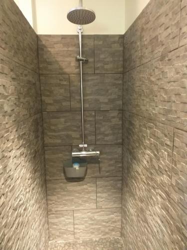 a bathroom with a shower with a stone wall at la grange in Eu