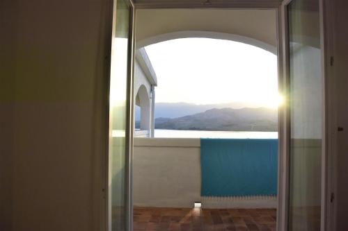 a mirror in a bathroom with a view of a window at Apartments Alma in Pag