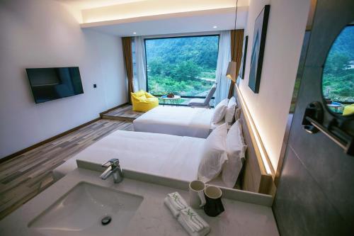 a hotel room with a sink and a large window at National Forest Park(Yangjiajie ) MINI Inn in Zhangjiajie