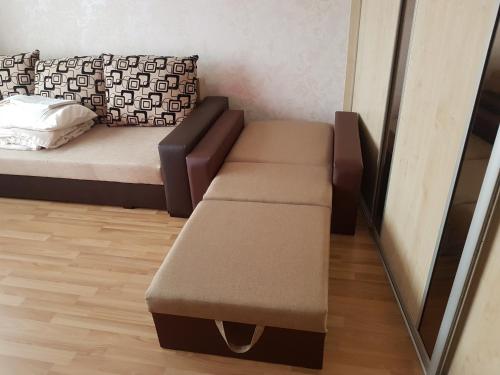 un letto con una panca in una stanza con uno specchio di Apartamenti Auseklis a Valmiera
