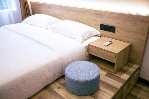 a bedroom with a bed with a table and a stool at National Forest Park(Yangjiajie ) MINI Inn in Zhangjiajie