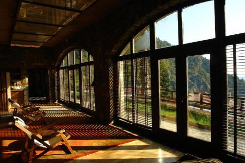 a room with large windows with a view of the mountains at Montanema Handmade Village in Platanákos