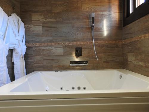 a white bath tub in a bathroom with a phone at El Molí de Pontons suites con jacuzzi spa in Pontons