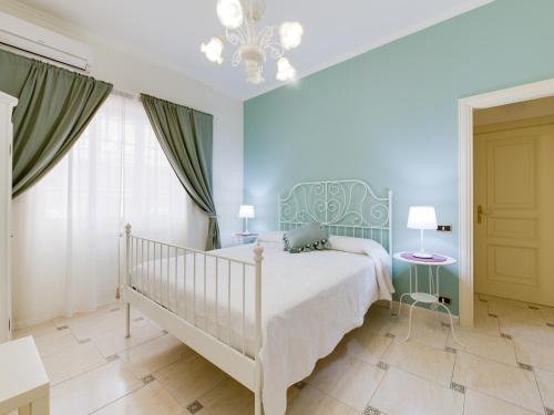a bedroom with a white bed and a blue wall at Il canto delle Sirene in Anzio