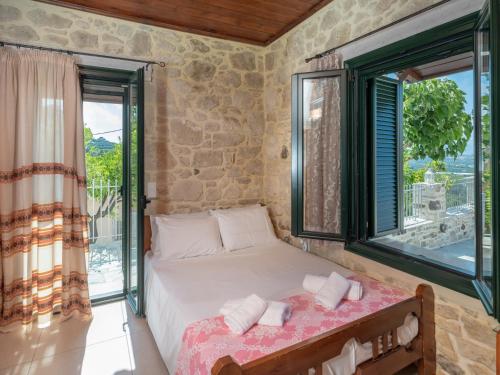 a bedroom with a bed and a large window at Traditional House in Kouses in Kousés