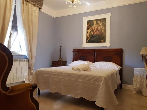 a bedroom with a bed with a painting on the wall at Locanda Elena in Equi Terme