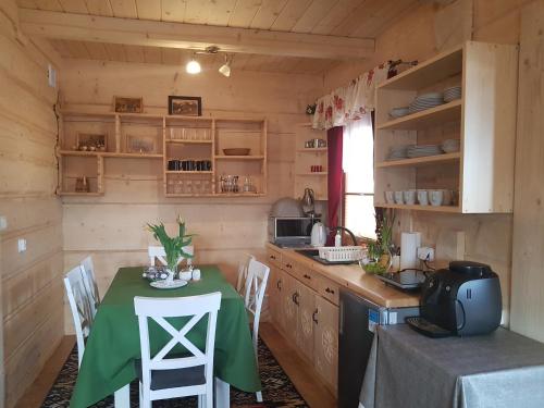 a kitchen with a table with a green table cloth at Domki w Białce pod Basenami, 50 m od term i wyciągów in Białka Tatrzanska