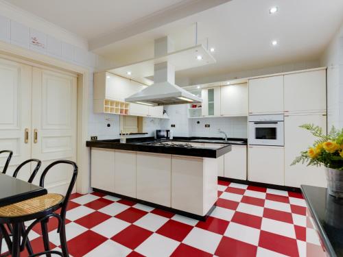 a kitchen with white cabinets and a red and white checkered floor at Il canto delle Sirene in Anzio