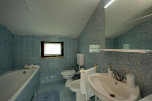ein Badezimmer mit einer Badewanne, einem Waschbecken und einem WC in der Unterkunft APP FIORELA in Poreč