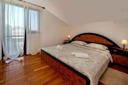 ein Schlafzimmer mit einem großen Bett und einem großen Fenster in der Unterkunft APP FIORELA in Poreč