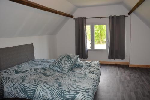 een slaapkamer met een bed en een raam bij Au Moulin de Rotteleux in Senarpont