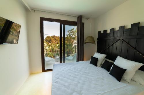 a bedroom with a large bed with a large window at PAIISE Hotels in Sant Francesc de s'Estany