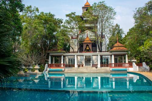 a house with a swimming pool in front of a building at Comfosya BBQ Pool Villa near Jomtien Beach in Na Jomtien