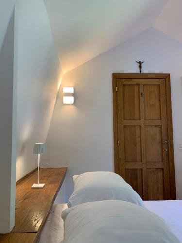 a bedroom with a bed and a wooden door at La Porterie de l’Abbaye de Marche les Dames in Namur