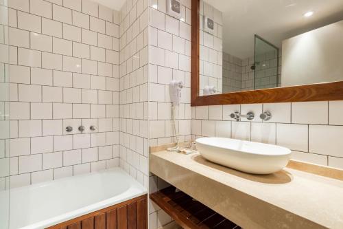 ein Badezimmer mit einem weißen Waschbecken, einer Badewanne und einem Waschbecken in der Unterkunft PALERMO EVOQUE Thames in Buenos Aires