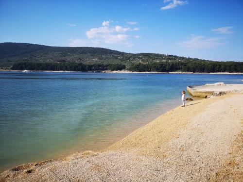 a person standing on a beach near the water at Naomi's Sunshine in Cres