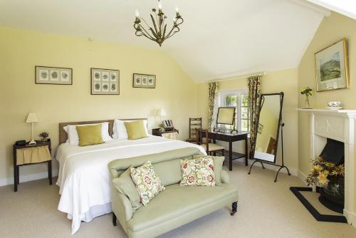 a bedroom with a bed and a chair and a fireplace at Church Farm B&B near Telford and Ironbridge in Shifnal