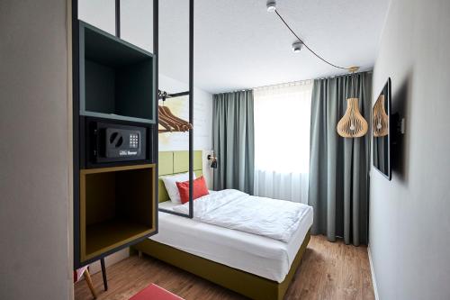 een kleine slaapkamer met een bed en een televisie bij Best Western Hotel Viernheim Mannheim in Viernheim