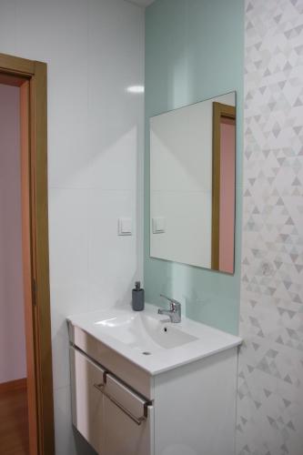 a bathroom with a white sink and a mirror at Aveiro2stay in Aveiro