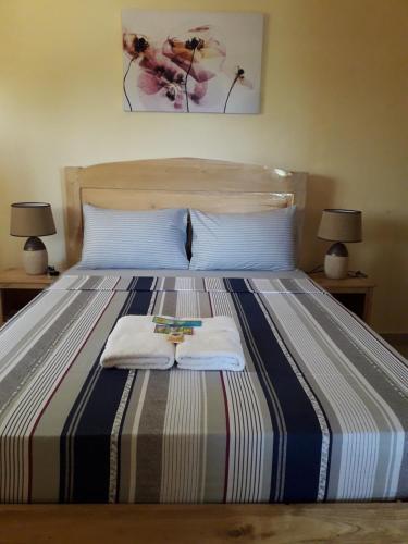 sypialnia z łóżkiem z 2 ręcznikami i 2 lampami w obiekcie Gal's Guesthouse w mieście Siquijor