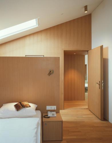 a bedroom with a bed and a door with a phone at Hotel Gasthof Grüner Baum in Glorenza