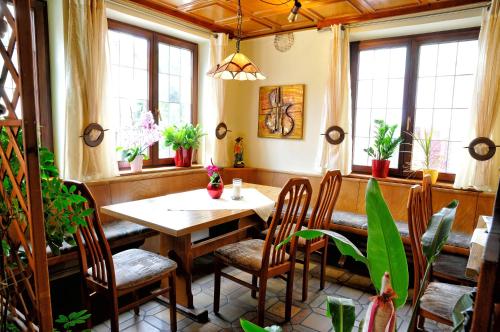 a dining room with a table and chairs and windows at Hotel Nothwang in Sindringen