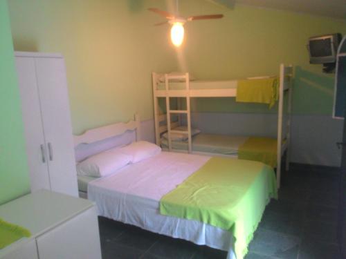 a bedroom with two bunk beds and a ceiling fan at Guest House Giulio Cesare in Búzios