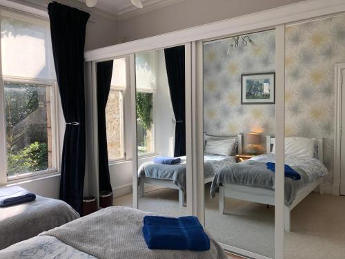 a bedroom with two beds and a mirror at 26 Belvidere Crescent Apartment in Aberdeen