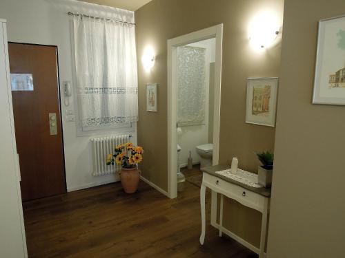 a bathroom with a toilet and a vase of flowers at Residenza Ofelia in Vicenza
