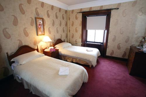 a hotel room with two beds and two lamps at Tayside Hotel in Stanley