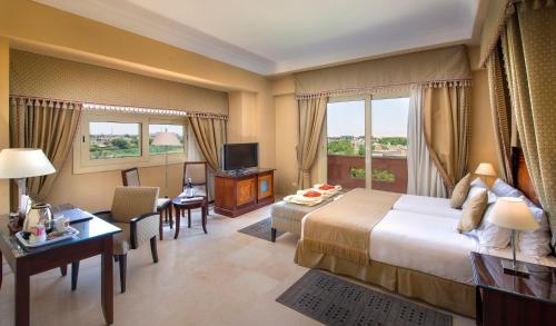 a hotel room with a large bed and a desk at Stella Golf Hotel in Ain Sokhna