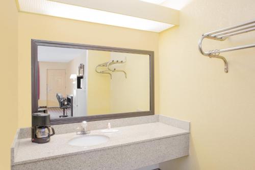 a bathroom with a sink and a large mirror at Days Inn by Wyndham Andalusia in Andalusia