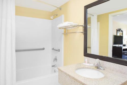 a bathroom with a sink and a mirror and a shower at Days Inn by Wyndham Andalusia in Andalusia