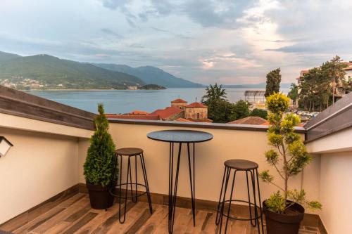 a balcony with two stools and a view of the water at Villa Varosh in Ohrid