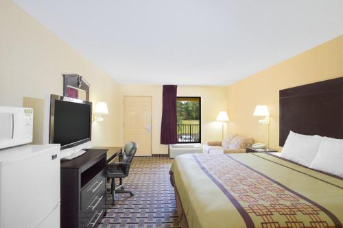 a hotel room with a bed and a flat screen tv at Days Inn by Wyndham Andalusia in Andalusia