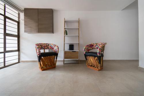 two chairs in a room with a table and a shelf at JUUB Colorful, Studio in New Polanco District (R1) in Mexico City