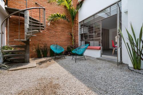 a patio with two chairs and a staircase next to a brick building at JUUB Colorful, Studio in New Polanco District (R1) in Mexico City