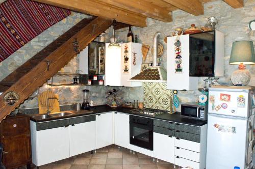 a kitchen with white cabinets and black counter tops at Casa Batia in Cefalù