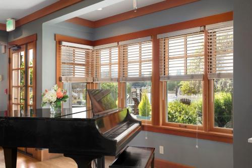 a grand piano in a room with windows at La Conner Channel Lodge in La Conner