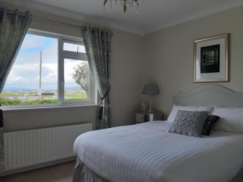 sypialnia z łóżkiem i dużym oknem w obiekcie Edenvale Bed & Breakfast w mieście Portnoo
