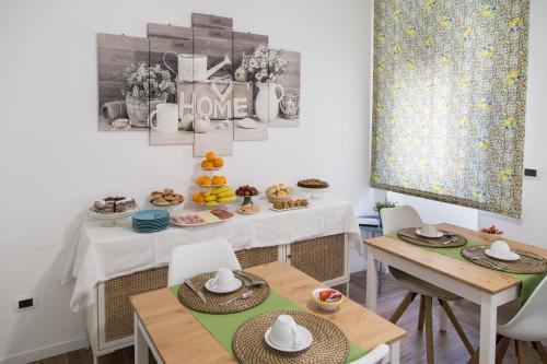 a dining room with a table and chairs with food on it at AmaSi Affittacamere in Siracusa