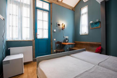 a bedroom with a bed and a blue wall at 3 Heritage Rooms in Tbilisi City