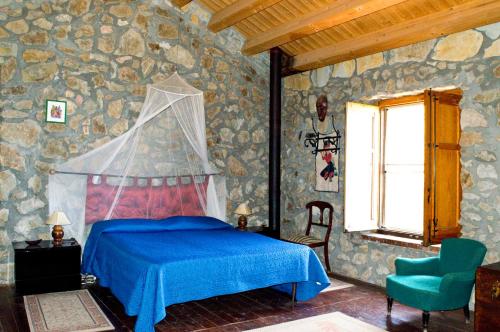 a bedroom with a blue bed and a chair at Casa Batia in Cefalù