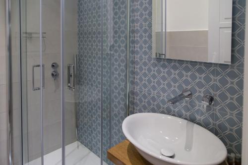 a bathroom with a sink and a glass shower at AmaSi Affittacamere in Siracusa
