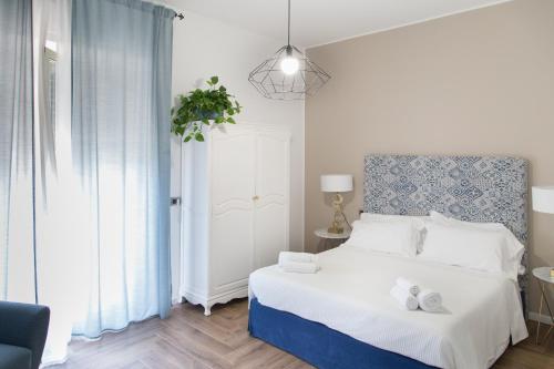 a bedroom with a bed with a blue and white headboard at AmaSi Affittacamere in Siracusa